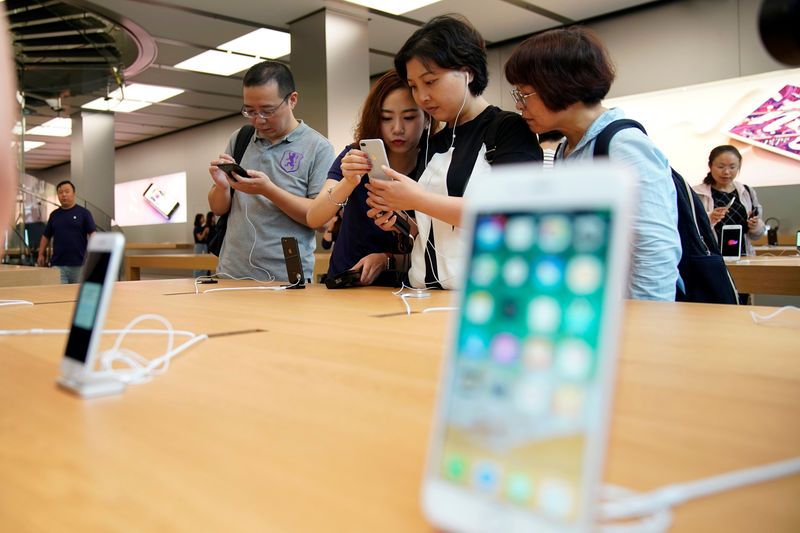 © Reuters. FILE PHOTO - Customers look at  Apple's new iPhone 8 Plus after it goes on sale at an Apple Store in Shanghai