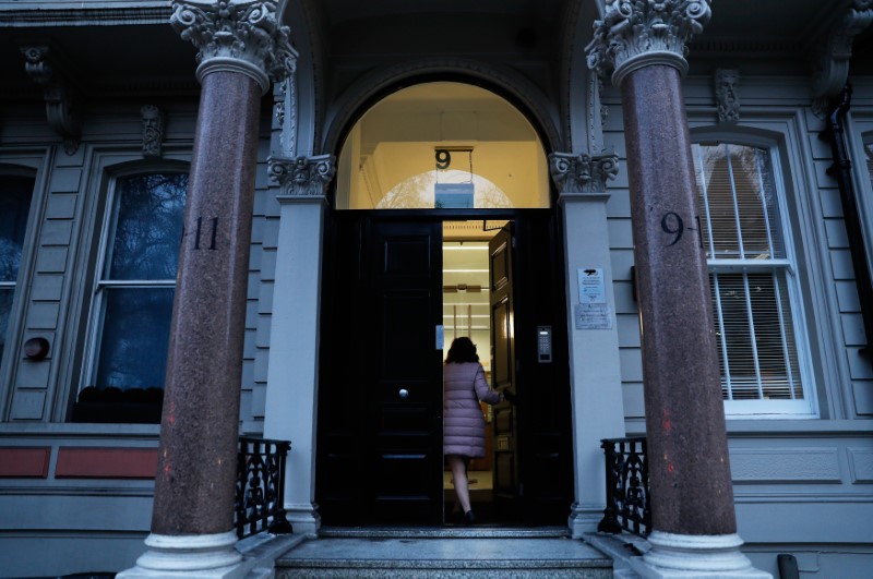 © Reuters. A woman enters the building housing the offices of Orbis Buiness Intelligence (C) where former British intelligence officer Christopher Steele works, in central London