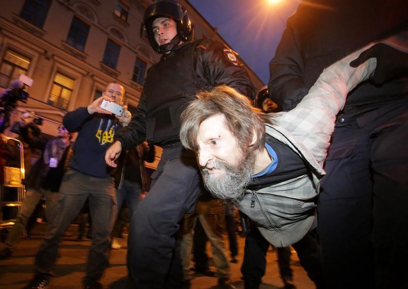© Reuters. Полицейские задерживают участника акции в поддержку Алексея Навального