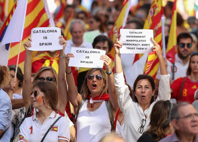 © Reuters. People hold up signs as they attend a pro-union demonstration organised by the Catalan Civil Society organisation in Barcelona