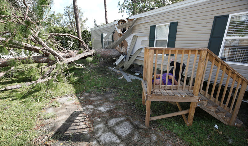 © Reuters. A resident of a mobile home park lies near a home that was destroyed by a falling tree in the wake of Hurricane Irma in Kissimmee