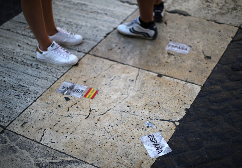 © Reuters. People stand next to stickers on the ground outside the regional government headquarters in Barcelona