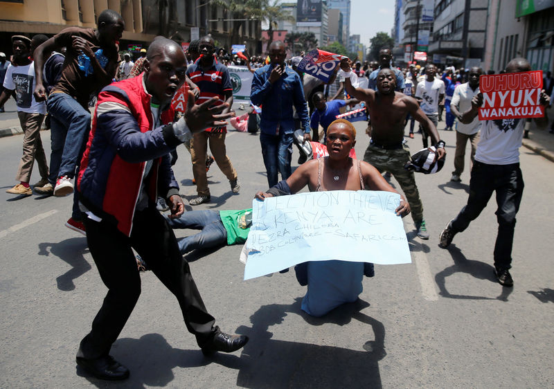 © Reuters. Supporters of the opposition National Super Alliance (NASA) coalition, carry banners and react during a protest calling for the sacking of election board officials involved in August's cancelled presidential vote, in Nairobi