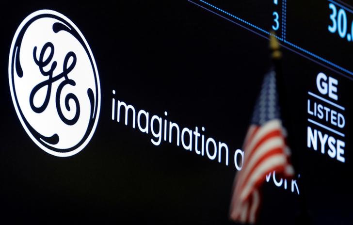 © Reuters. FILE PHOTO -The ticker and logo for General Electric Co. is displayed on a screen at the post where it's traded on the floor of the NYSE