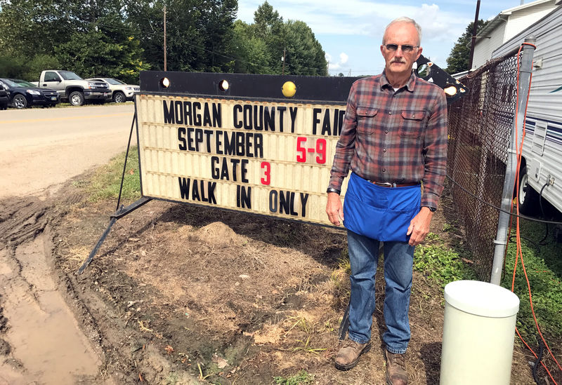 © Reuters. Wilson, 70, stands next to a sign at the Morgan County Fair in McConnelsville