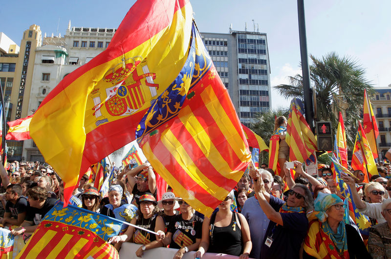 © Reuters. Right-wing demonstrators waving Spanish and Valencian flgs insult local leftist politicians accusing them to sympathize with the Catalan separatist movement during the festivities of the regional day in Valencia