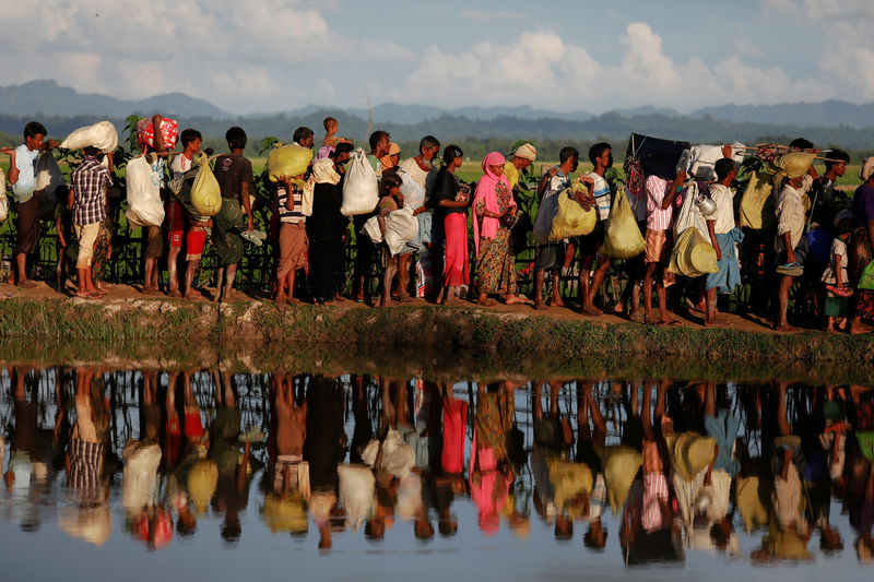 © Reuters. Rohingya refugees who fled from Myanmar wait to be let through by Bangladeshi border guards after crossing the border in Palang Khali