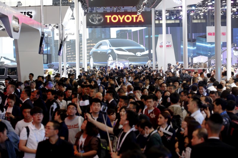 © Reuters. FILE PHOTO: Visitors are seen between Toyota Motor Corp's and other companies booths during Auto China 2016 auto show in Beijing