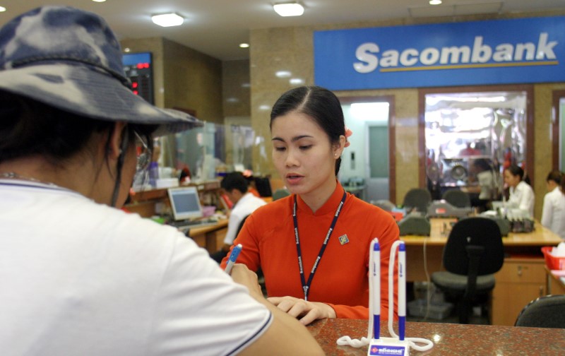 © Reuters. Customer talks with Saigon Thuong Tin commercial bank's staff at bank's headquarter in Ho Chi Minh city
