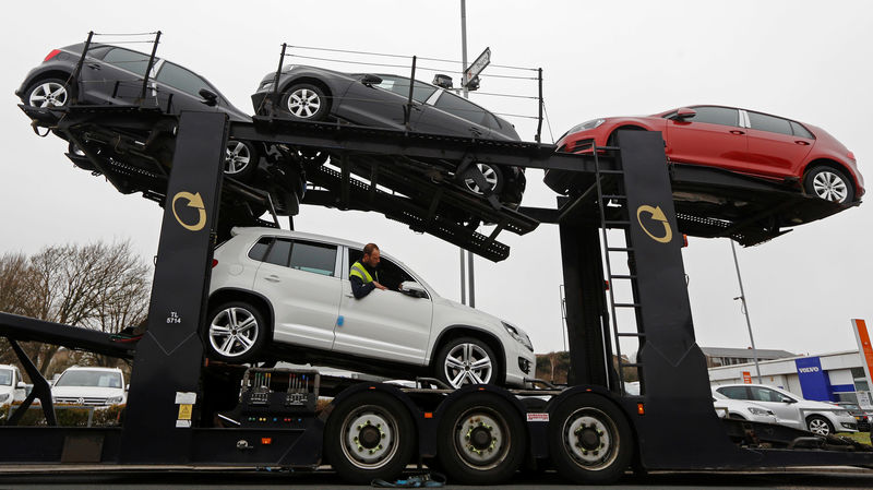 © Reuters. FILE PHOTO: A man unloads Volkswagen cars from a car transporter outside a car showroom at Portslade near Brighton