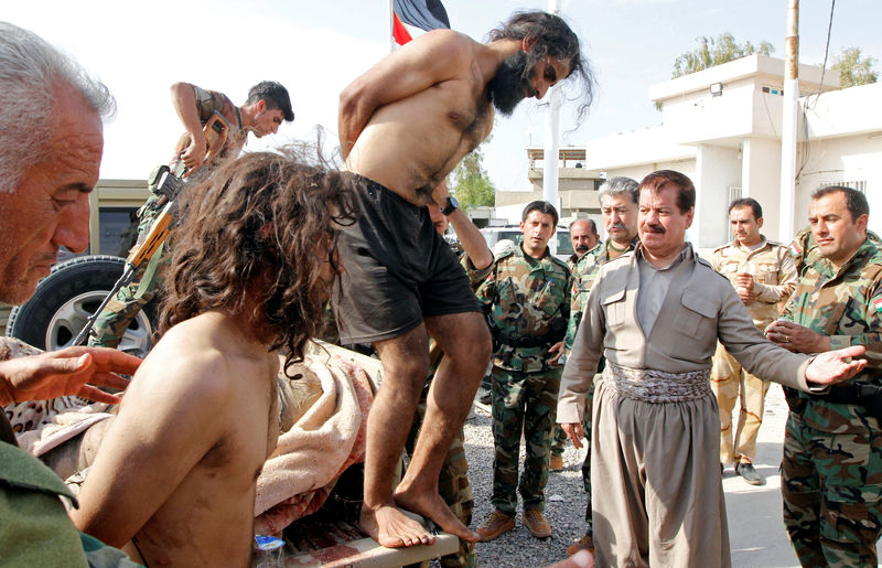 © Reuters. Kurdish Peshmerga forces detain men suspected of being Islamic State militants southwest of Kirkuk