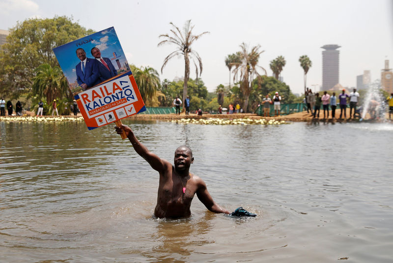 © Reuters. A supporter of Kenyan opposition National Super Alliance (NASA) coalition, carries a banner depicting Kenyan opposition leader Raila Odinga and his running-mate Kalonzo Musyoka, during a demonstration in Nairobi