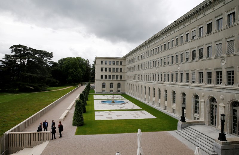 © Reuters. FILE PHOTO: People talk outside the headquarters of the World Trade Organisation WTO in Geneva
