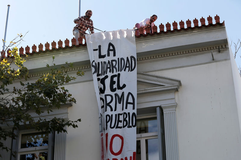 © Reuters. Funcionários da embaixada da Espanha removem faixa pedurada por anarquistas autodeclarados a favor da independência da Catalunha, em Atenas, na Grécia