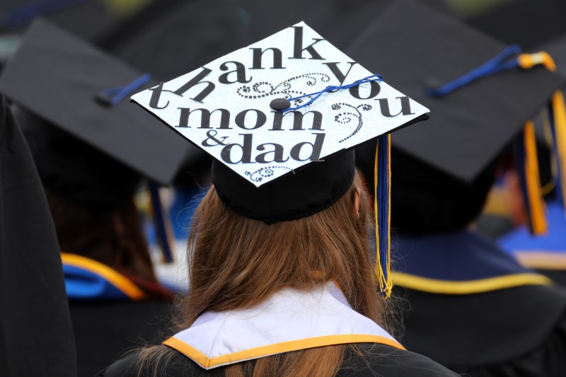 © Reuters. Messages and artwork are pictured on the top of the caps of graduating students during their graduation ceremony at UC San Diego in San Diego