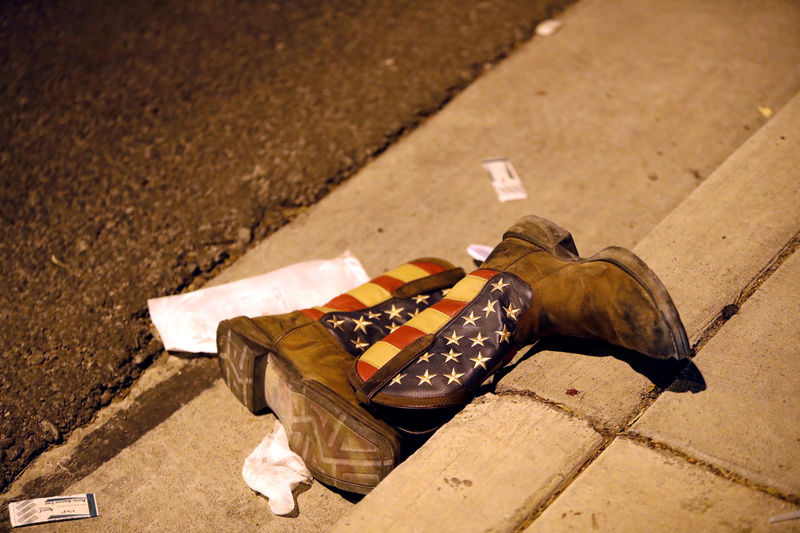 © Reuters. A pair of cowboy boots is shown in the street outside the concert venue after a mass shooting at a music festival on the Las Vegas Strip in Las Vegas