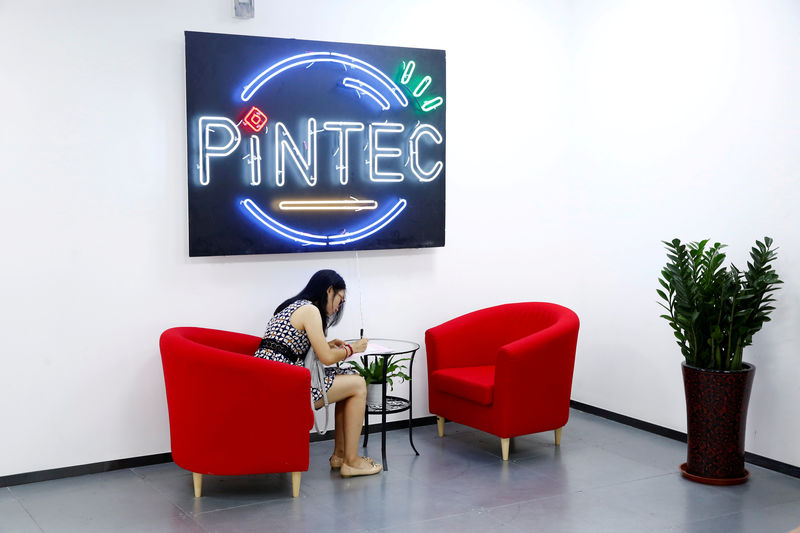 © Reuters. FILE PHOTO: A woman sits in the reception area of PINTEC Group in Beijing