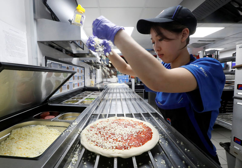 © Reuters. FILE PHOTO: A staff member prepares a pizza at a Domino's Pizza restaurant in Moscow