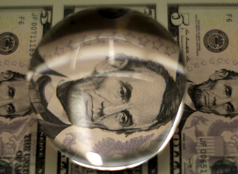 © Reuters. FILE PHOTO: Sheets of Lincoln five dollar bill are inspected with magnifying glass at  Bureau of Engraving and Printing in Washington