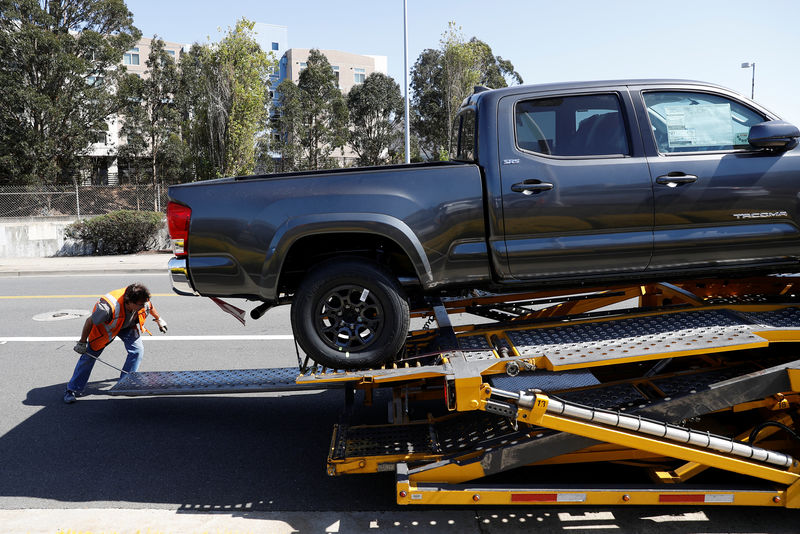 © Reuters. A worker moves a ramp on a car carrier trailer outside City Toyota in Daly City, California