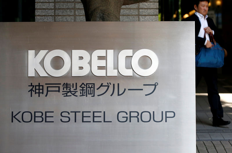 © Reuters. FILE PHOTO: A man walks past the signboard of Kobe Steel at the group's Tokyo headquarters in Tokyo