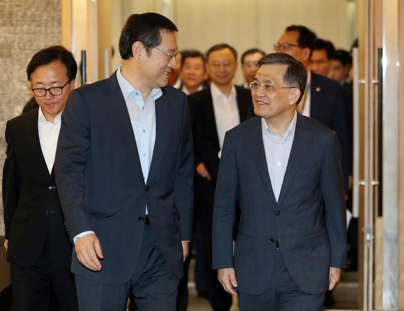 © Reuters. FILE PHOTO - Lee Yong-sup (C), vice chairman of the Presidential Jobs Committee, talks with Samsung Electronics Vice Chairman Kwon Oh-hyun as they arrive to attend a meeting in Seoul