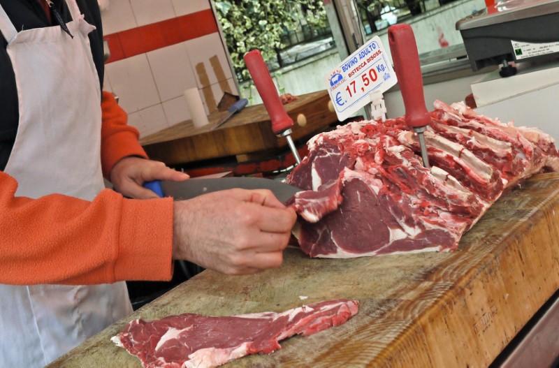 © Reuters. A butcher cuts up beef at a street market in Rome