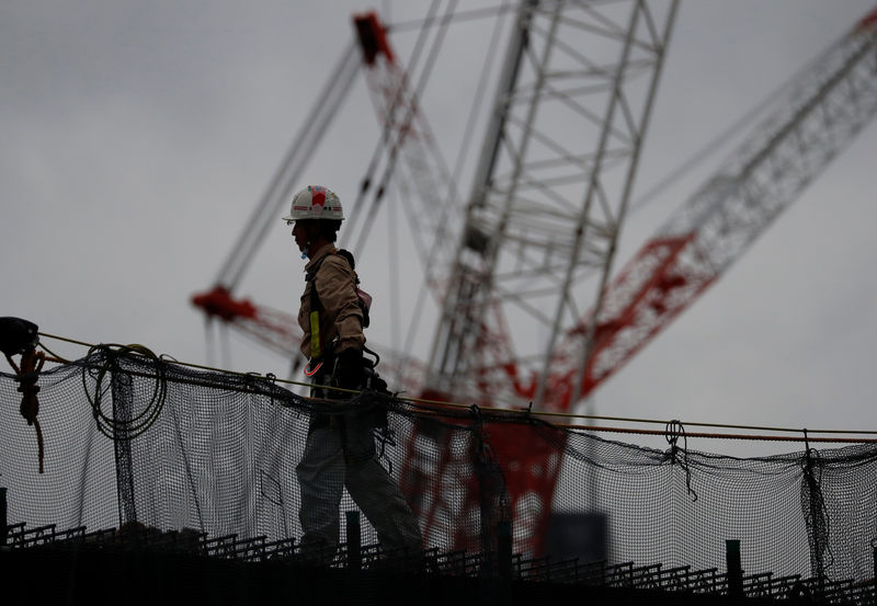 © Reuters. A man works at the construction site of the New National Stadium, the main stadium of Tokyo 2020 Olympics and Paralympics in Tokyo