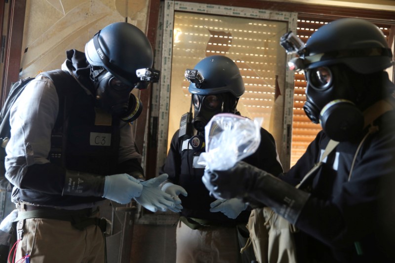 © Reuters. FILE PHOTO: UN chemical weapons expert holds a plastic bag containing samples from one of the sites of an alleged chemical weapons attack in Ain Tarma