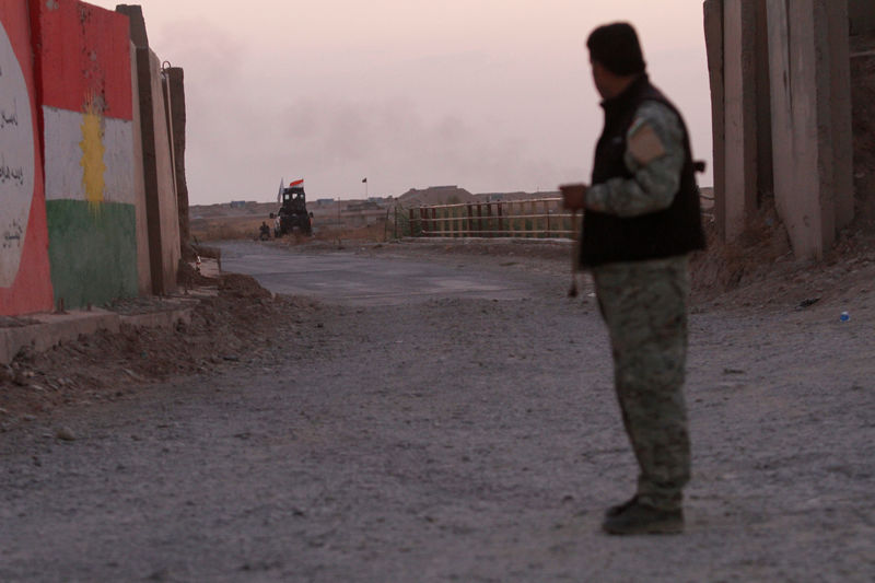 © Reuters. A Kurdish Peshmerga fighter looks at the Shi'ite Popular Mobilization Forces (PMF) in the Southwest of Kirkuk