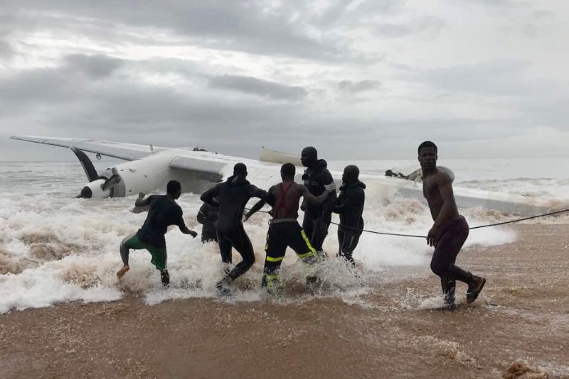 © Reuters. People pull the wreckage of a propeller-engine cargo plane after it crashed in the sea near the international airport in Ivory Coast's main city, Abidjan