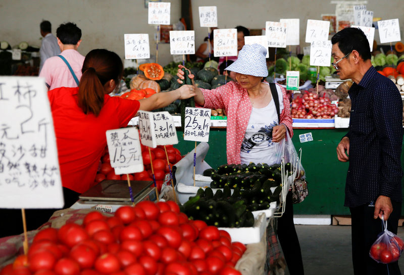 © Reuters. FILE PHOTO: People buy vegetables at a fresh food market in Beijing