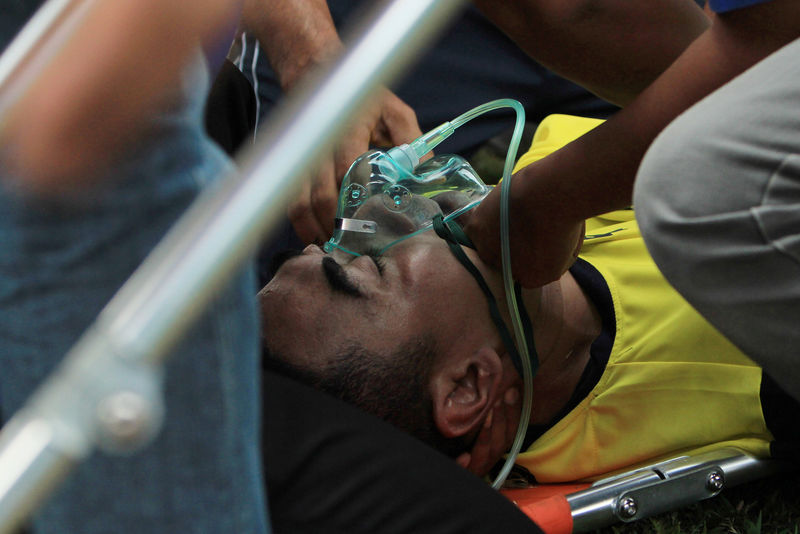 © Reuters. Indonesian goalkeeper Choirul Huda of the Persela Lamongan soccer club receives medical treatment after an injury during a match against Semen Padang soccer club in Lamongan
