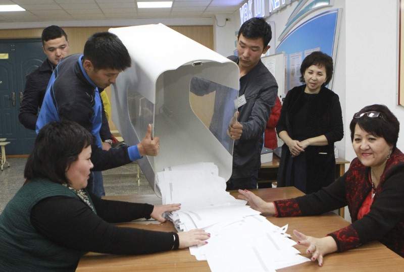 © Reuters. Members of a local electoral commission empty a ballot box at a polling station after a presidential election in Bishkek