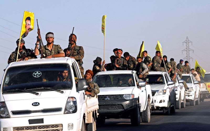 © Reuters. Fighters of Syrian Democratic Forces ride on trucks as their convoy passes in Ain Issa