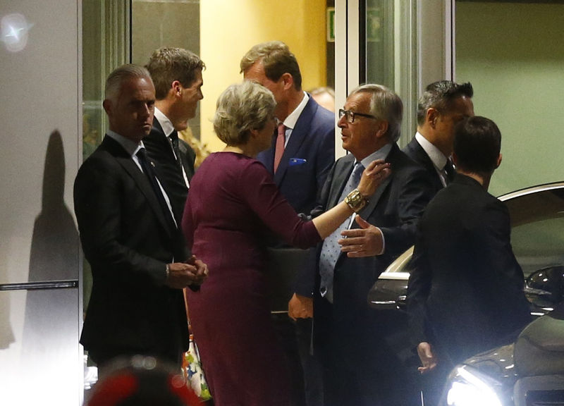 © Reuters. Britain’s Prime Minister Theresa May is greeted by European Commission President Jean-Claude Juncker while leaving the European Commission headquarters after a meeting in Brussels,