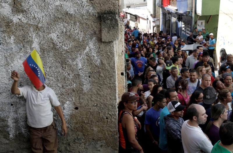 © Reuters. Venezuelan citizens wait in line at a polling station during a nationwide election for new governors in Caracas
