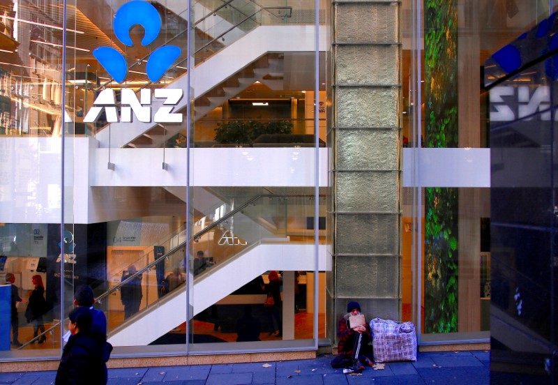 © Reuters. FILE PHOTO: A man who claims to have been homeless for over 30 years begs for money as he sits outside a branch of the ANZ Banking Group in central Sydney, Australia