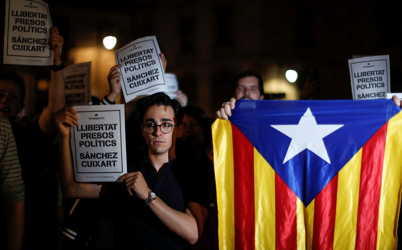 © Reuters. Protesters hold up signs reading " Freedom Political Prisoners, Sanchez Cuixart" outside the regional government headquarters after Spain's High Court jailed the leaders of two of the largest separatist organizations, the Catalan National Assembly's Jordi