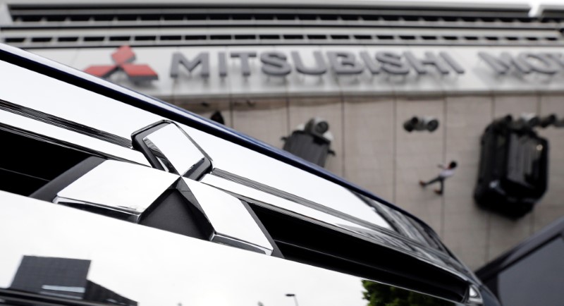 © Reuters. Mitsubishi Motors Corp's logo on a car and its company headquarters are seen in Tokyo