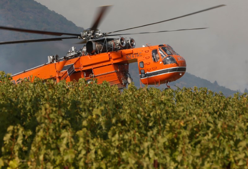 © Reuters. Firefighting helicopters work to contain a wildfire near Oakville