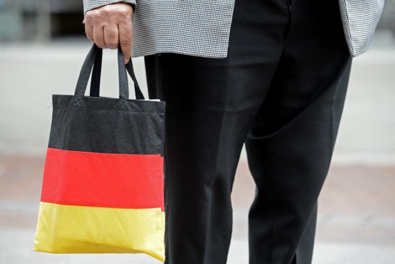 © Reuters. Man carries a shopping bag in the colours of the German national flag in downtown Hanove