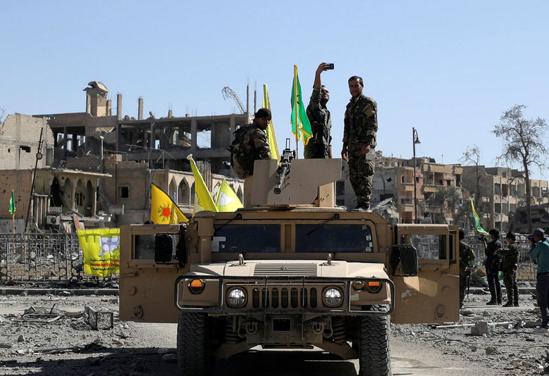 © Reuters. Combatente das Forças Democráticas da Síria (FDS) tira foto em cima de veículo militar em Raqqa, na Síria