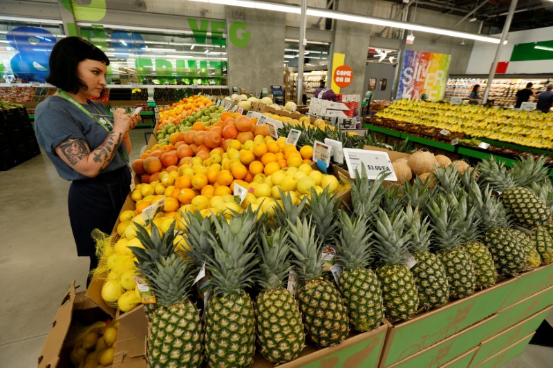 © Reuters. FILE PHOTO: An employee checks prices of lemons at a 365 by Whole Foods Market grocery store