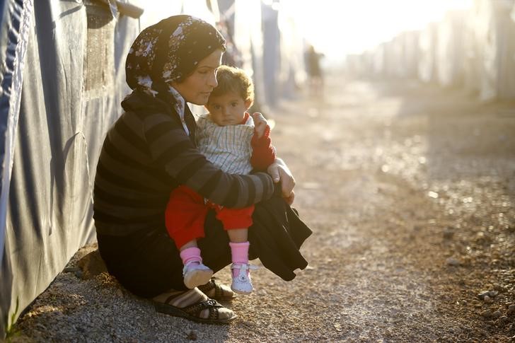 © Reuters. Refugiada curda segura criança em campo de refugiados na cidade de Suruç, na Turquia