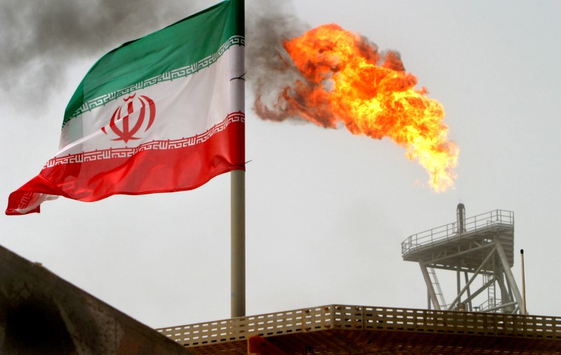 © Reuters. FILE PHOTO: A gas flare on an oil production platform in the Soroush oil fields is seen alongside an Iranian flag in the Gulf