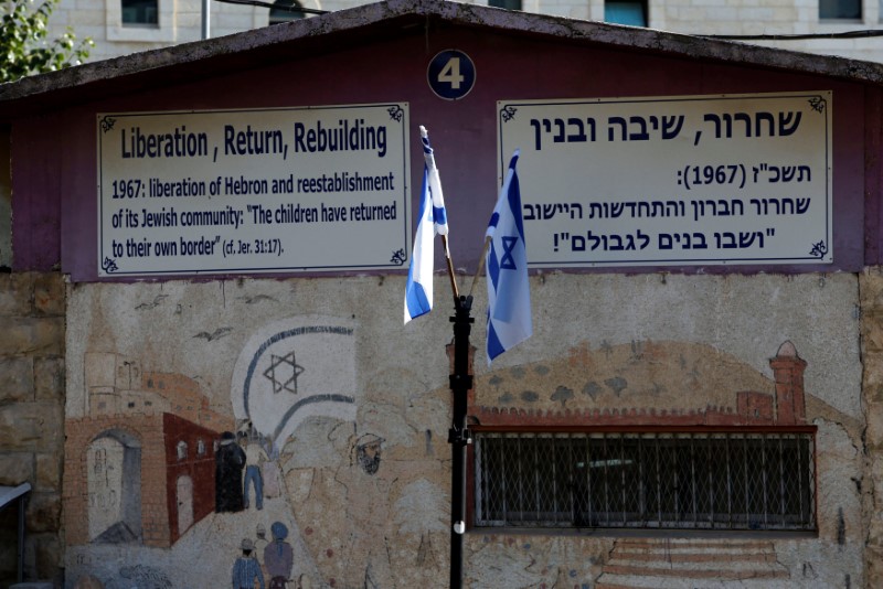 © Reuters. Israeli flags and signs are seen at a military camp in the West Bank city of Hebron