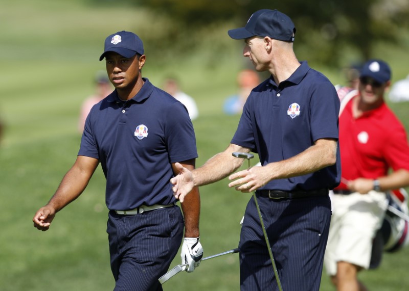© Reuters. U.S. golfers Woods and Furyk walk to the third green during a practice round at the 39th Ryder Cup golf matches at the Medinah Country Club in Medinah