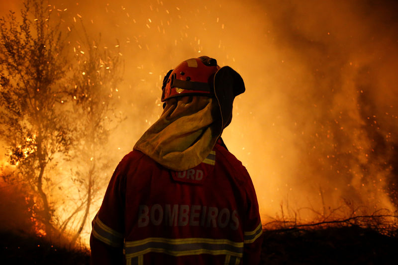 © Reuters. Bombeiro é visto perto de chamas em incêndio florestal em Cabanões, Portugal