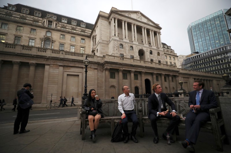 © Reuters. People sit outside the Bank of England in London